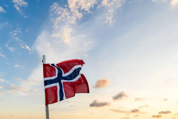 stock image Norwegian flag, a flag of Norway with sunset background. 