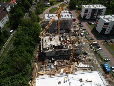 Vinçlerin İkamet Binasında Çalışırken İHA görüntüsü İHA 'nın bir inşaat sahasında çalışırken çektiği vinç görüntüsü. Görüntü, apartman bloklarının inşaatı üzerinde çalışan birden fazla vinç gösteriyor.