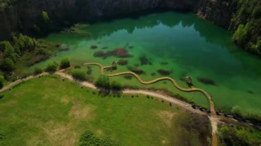 Serene Gazebo, Vibrant Green Lake Rıhtımı Havadan canlı yeşil bir göle giden ahşap bir iskelenin manzarası Serene Gazebo, Vibrant Green Lake Havalimanı, ahşap bir rıhtım manzarası..