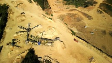 Çalışan Kamyon ve Taşıyıcılarla Dolomite Quarry 'nin hava görüntüsü bu hava görüntüsü aktif bir dolomit ocağını gösteriyor. Taşıma bantları ve kamyonlar malzeme taşıma ve sıralama sürecinde görülebilirler. Sarı kum farklı bir ülke yaratır.