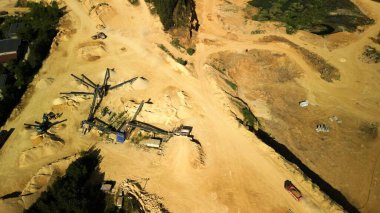 Aerial View of Dolomite Quarry with Working Trucks and Conveyors This aerial image showcases an active dolomite quarry. Conveyor belts and trucks are visible in the process of transporting and sorting material. The yellow sand creates a distinct land clipart