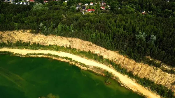 Orman Uçurumunun Havadan Bakışı Uzakta Residential Area Göle Bakıyor Havadan bakıldığında aşağıdaki dingin göle düşen dramatik bir orman uçurumu görülüyor. Orman uçurumun kenarına kadar uzanıyor, çarpıcı bir kontrast zekası yaratıyor.