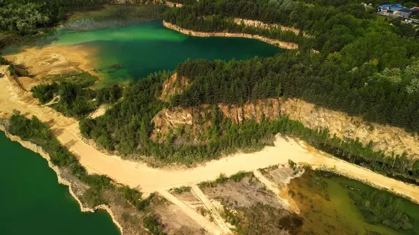 Kumlu Yol ve Ağaçlar ile ayrılmış Two Lakes 'in havadan görünüşü, sığ alanlar ile bu hava manzarası kumlu bir yol ile ayrılmış ve ağaçlarla çevrili iki göl yakalar. Görüntü her iki göl içindeki sığ alanları vurguluyor, doku ve ilgi ekliyor