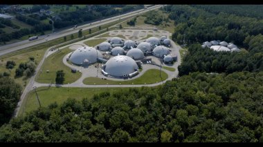 Bağlı Kubbeler ve Yakın Sokak 'la Gizemli Bir Üs' ün Uzaktan Görünümü şeffaf cam tünellerle birbirine bağlı gizemli bir üssün büyüleyici uzak görüntüsü. Sahne, tüm kompleksi bir şehir merkezine karşı sergiliyor.