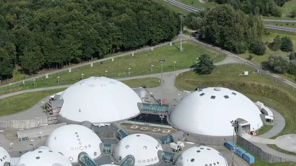 UFO Tasarımına Benzeyen Geleceğin Dome Kompleksi, UFO 'ları çağrıştıran fütüristik bir kubbe kompleksinin ilgi çekici bir hava görüntüsü. Birbirine bağlı kubbelerin gösterişli, yuvarlak formları daha alengirli görünen bir mimari yapı oluşturur.