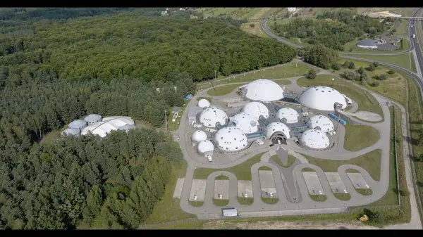 Diğer Dünya Kompleksi 'nin hava görüntüsü UFO Üssü' nü andırıyor. Başka bir dünyadan bir üsse benzeyen kubbe şekilli yapıların fütürist bir kompleksin nefes kesen görüntüsü. Eşsiz tasarım, çevresini çevreleyen ormanla birleşince...