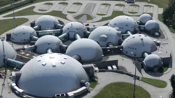 Altın Güneş Işığındaki Parlak UFO 'lardan etkilenen Kubbeler Kubbe şeklindeki binalar altın güneş ışığıyla güzelce aydınlatılarak daha da yabancı ve fütüristik görünmelerini sağlıyorlar. Kıvrımlı, yansıtıcı yüzeyleri ışığı yakalar ve ışık saçar.
