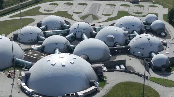 Güneşli UFO benzeri Kubbeler Fütürist Zarafeti Parıldatıyor. Güneş ışığı zarif bir şekilde kubbenin yapılarını aydınlatıyor ve parlak, fütüristik tasarımlarını ön plana çıkarıyor. Pürüzsüz yüzeyler ışığı yansıtarak, onların UFO benzeri görünümünü güçlendirir.