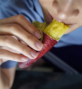 Asyalı kadın Tatlı Patates yiyor. Kapalı çekim..