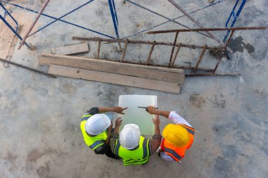 Mimar mühendislerinin üst görüşü inşaat planının ilerlemesi hakkında tartışıyorlar..