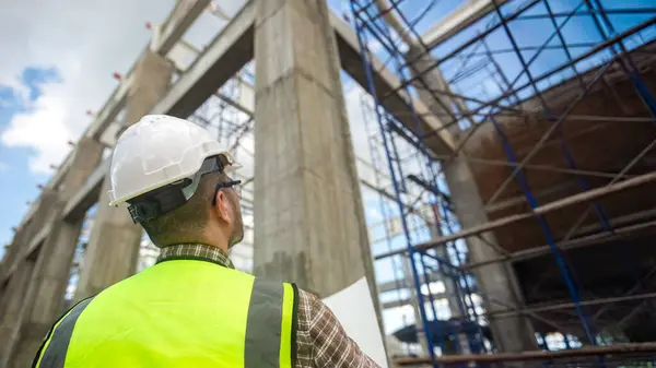 Mimar inşaat projesinin gidişatını ve bina yapısının doğruluğunu kontrol ediyor.
