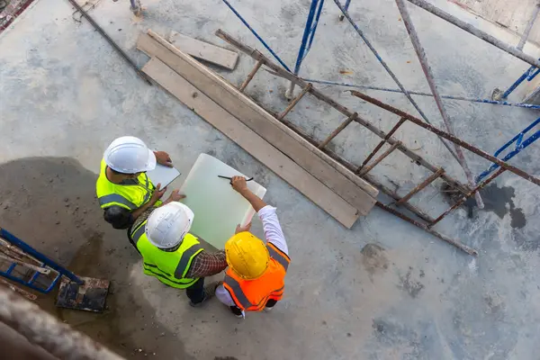 Mimar mühendislerinin üst görüşü inşaat planının ilerlemesi hakkında tartışıyorlar..