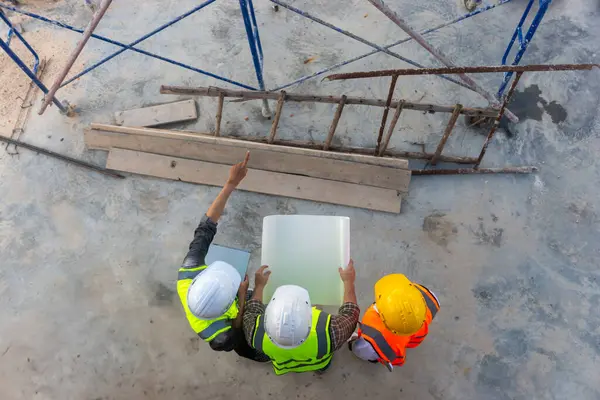 Mimar mühendislerinin üst görüşü inşaat planının ilerlemesi hakkında tartışıyorlar..