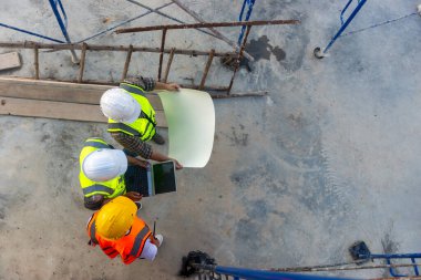 Mimar mühendislerinin üst görüşü, inşaat planının ilerlemesi hakkında tartışıyorlar.