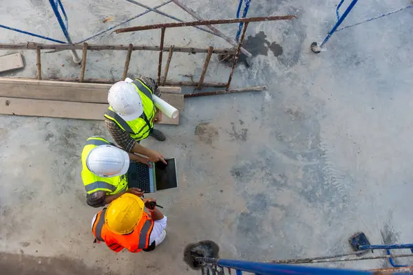 Mimar mühendislerinin üst görüşü, inşaat planının ilerlemesi hakkında tartışıyorlar.
