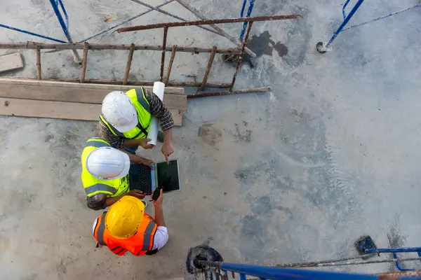 Mimar mühendislerinin üst görüşü, inşaat planının ilerlemesi hakkında tartışıyorlar.