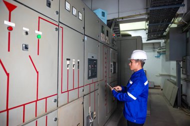 Elektrik mühendisi ana elektrik kontrol panelleri ve anahtarların işletimini kontrol et, tabletlerdeki kayıt değerleri