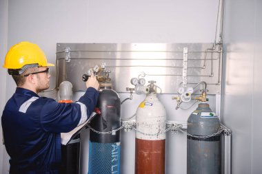 Mühendisler, sanayi tesisindeki gaz miktarını kontrol etmek için gaz tanklarının hacmini ve basınç vanalarını kontrol ediyor..