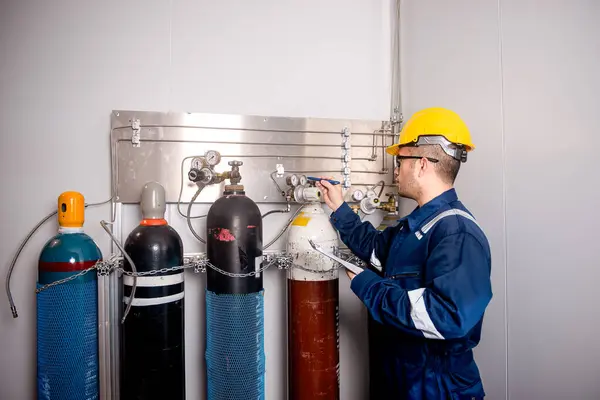 Mühendisler, sanayi tesisindeki gaz miktarını kontrol etmek için gaz tanklarının hacmini ve basınç vanalarını kontrol ediyor..
