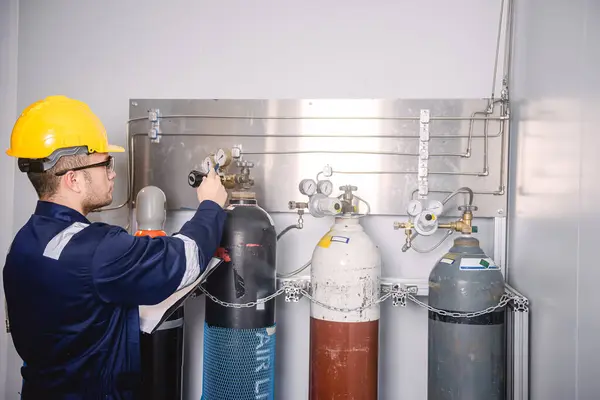 Mühendisler, sanayi tesisindeki gaz miktarını kontrol etmek için gaz tanklarının hacmini ve basınç vanalarını kontrol ediyor..