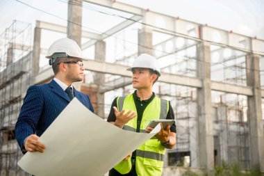 Mühendis ve mimar inşaat planının ilerlemesini izliyor ve bunların doğruluğunu doğruluyor..