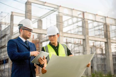 Mühendis ve mimar inşaat planının ilerlemesini izliyor ve bunların doğruluğunu doğruluyor..