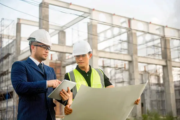 Mühendis ve mimar inşaat planının ilerlemesini izliyor ve bunların doğruluğunu doğruluyor..