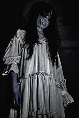 Perili bir odada beyaz bir elbise giyen nefret ve dehşet dolu bir yüzü olan kadın hayaletin portresi.