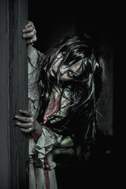 Bir kadın hayalet kafasını odanın kapısından dışarı çıkarıyordu ve korku içinde bakıyordu..