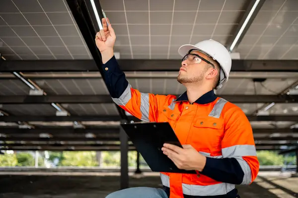 Erkek bakım mühendisi güneş panellerinin çalışmasını denetliyor ve tamirat yapıyor..