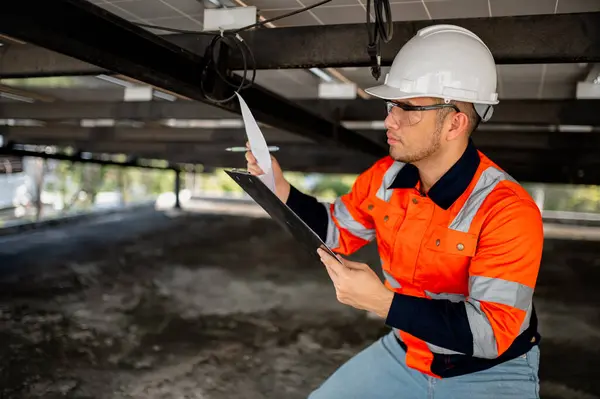 Erkek bakım mühendisi güneş panellerinin çalışmasını denetliyor ve tamirat yapıyor..