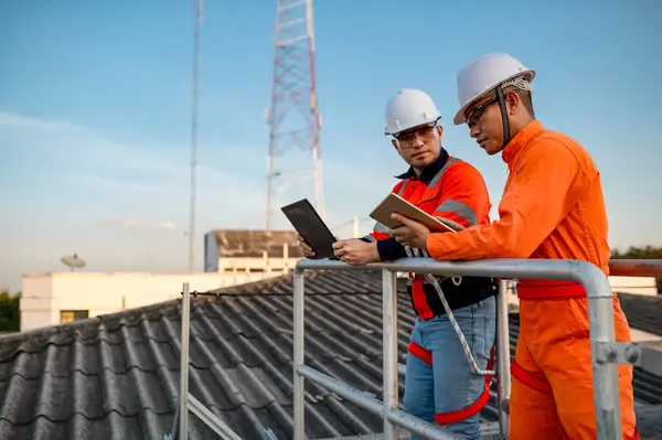 İki mühendis bir binanın çatısına güneş pilleri yerleştirmeyi planlıyor..