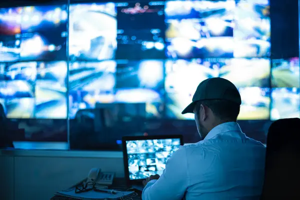 Güvenlik görevlileri birden fazla CCTV monitörünü izliyor ve meydana gelen olayları bildiriyor..