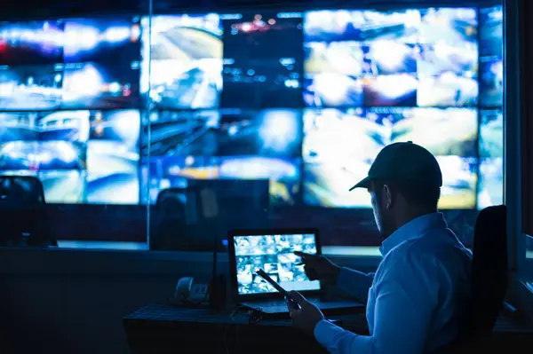 Güvenlik görevlileri birden fazla CCTV monitörünü izliyor ve meydana gelen olayları bildiriyor..