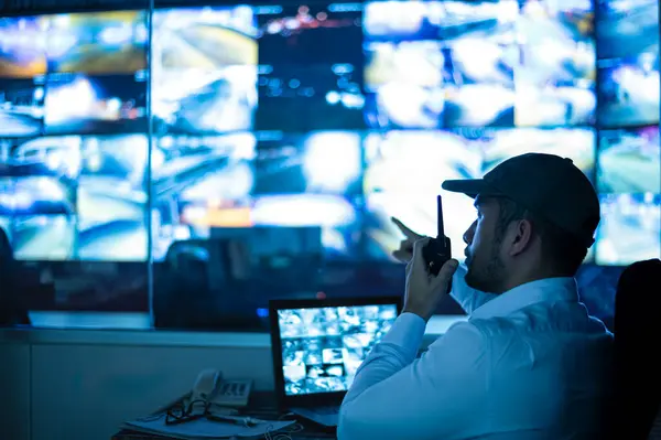 Güvenlik görevlileri birden fazla CCTV monitörünü izliyor ve meydana gelen olayları bildiriyor..