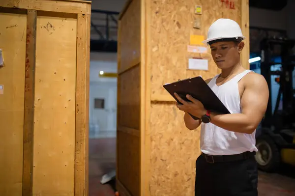 Çalışanlar büyük bir depodaki paket kutularını kontrol ediyorlar..