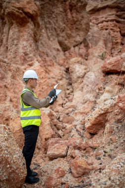Bir jeolog, araştırmalarını planlamak için planlarını bir panoda gözden geçirir.