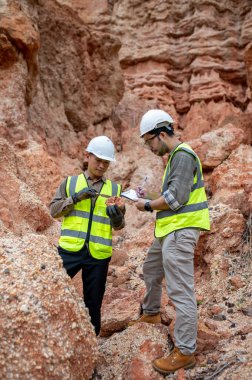 Jeologlar bir taş ocağında kazılan taşları toplar ve türlerini belirlemek için incelerler.