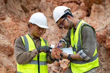 Jeologlar topraktaki mineralleri analiz etmek için taş topluyor.