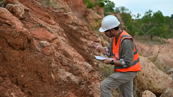 Jeologlar ellerindeki toprağı analiz edip kaydediyorlar.