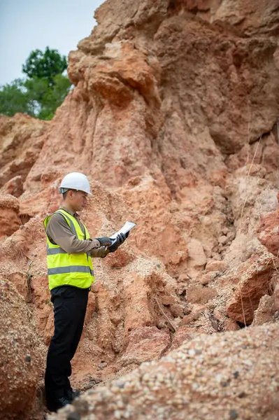 Bir jeolog, araştırmalarını planlamak için planlarını bir panoda gözden geçirir.