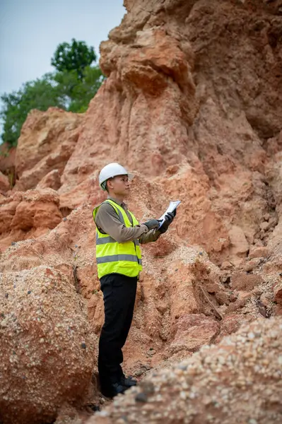 Bir jeolog, araştırmalarını planlamak için planlarını bir panoda gözden geçirir.