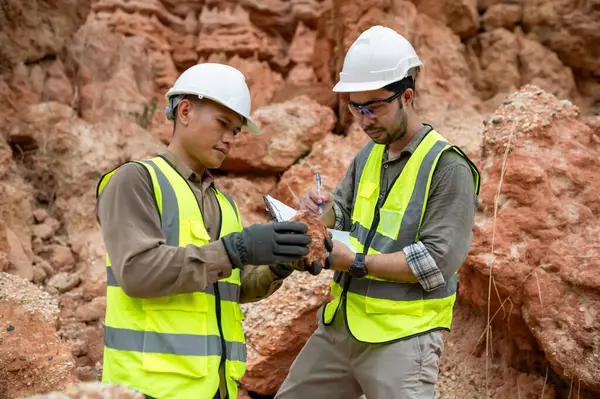 Jeologlar topraktaki mineralleri analiz etmek için taş topluyor.