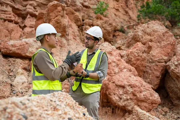 Jeologlar topraktaki mineralleri analiz etmek için taş topluyor.