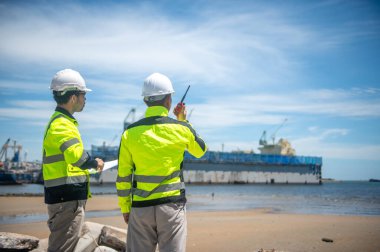 Liman yetkilileri kargo gemilerinin kıyıya yanaşması için bir yer hazırlıyorlar.