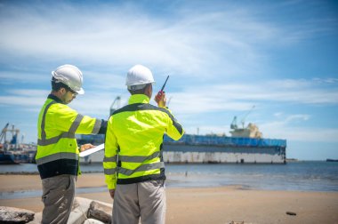 Liman yetkilileri kargo gemilerinin kıyıya yanaşması için bir yer hazırlıyorlar.
