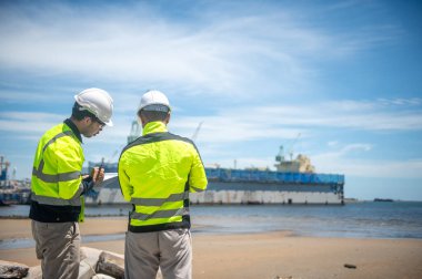 Liman yetkilileri kargo gemilerinin kıyıya yanaşması için bir yer hazırlıyorlar.