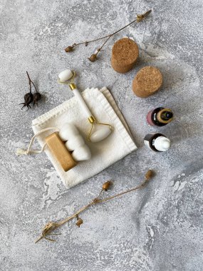 SPA seti ve doğal elementler. Yeşim silindir, fırça ve kozmetik mermer arka planda. Vücut güzelliği kavramı. Üst görünüm.