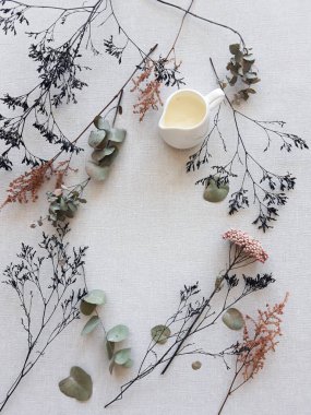 Hafif arka planda kurumuş çiçekler. Çerçeve şeklinde zarif dallar. Boşluğu kopyala