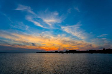 Jastarnia rıhtımından, sakin suları ve renkli gökyüzü ile Puck Körfezi 'nin üzerinde canlı bir günbatımı..